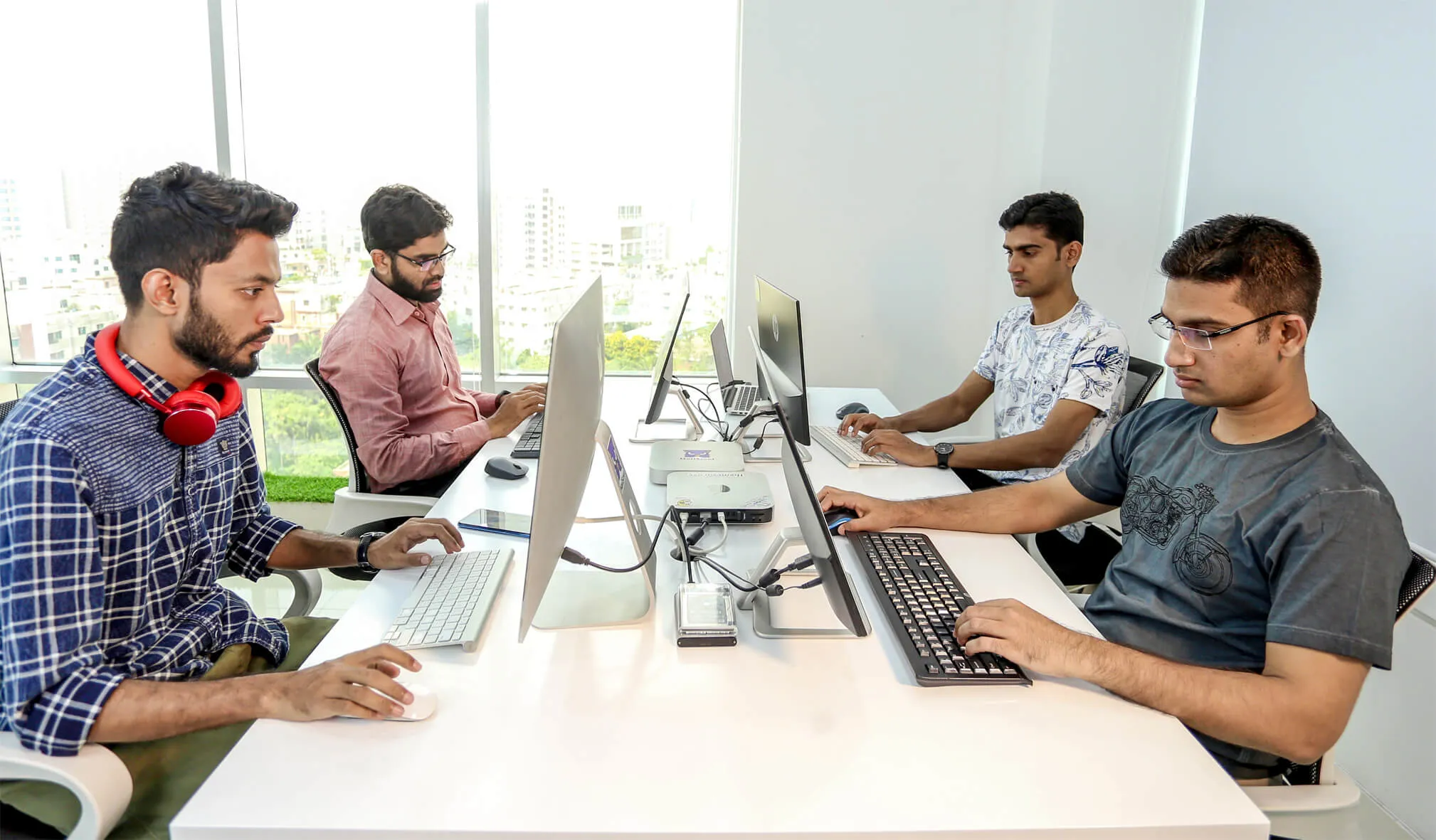Four developers at their desks in the Convers Labs office